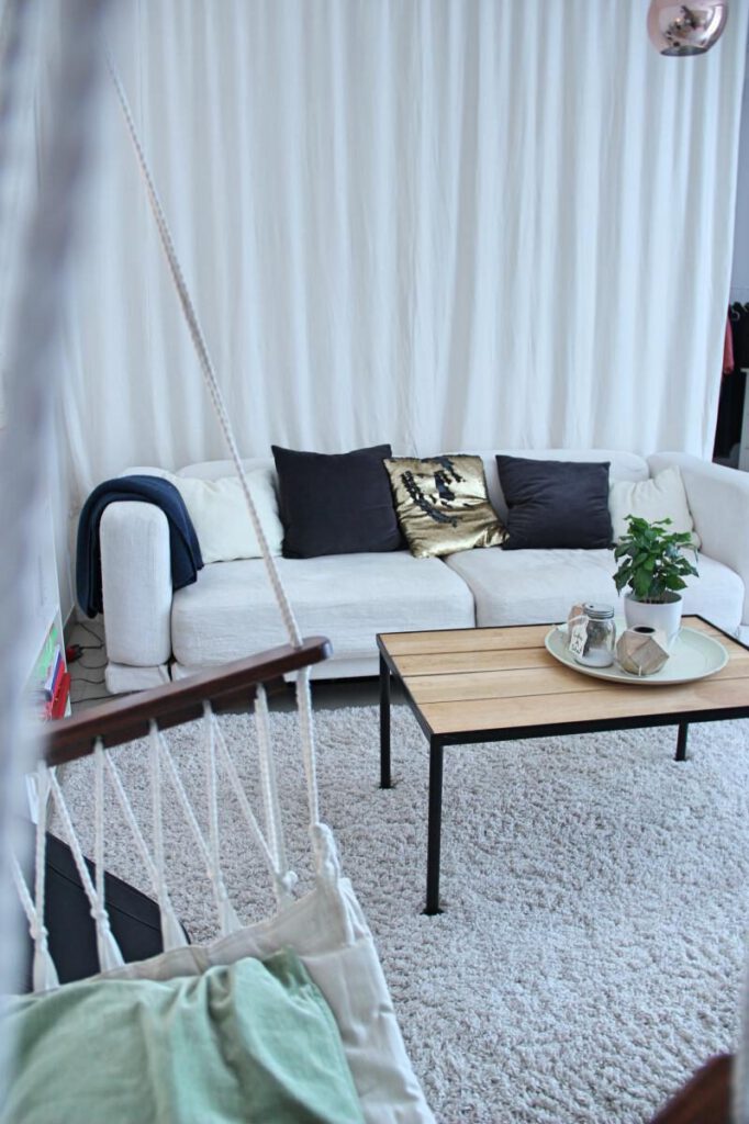 Ein Vorhang als Raumteiler, der den Schlafbereich in offenen Raum völlig abtrennt.