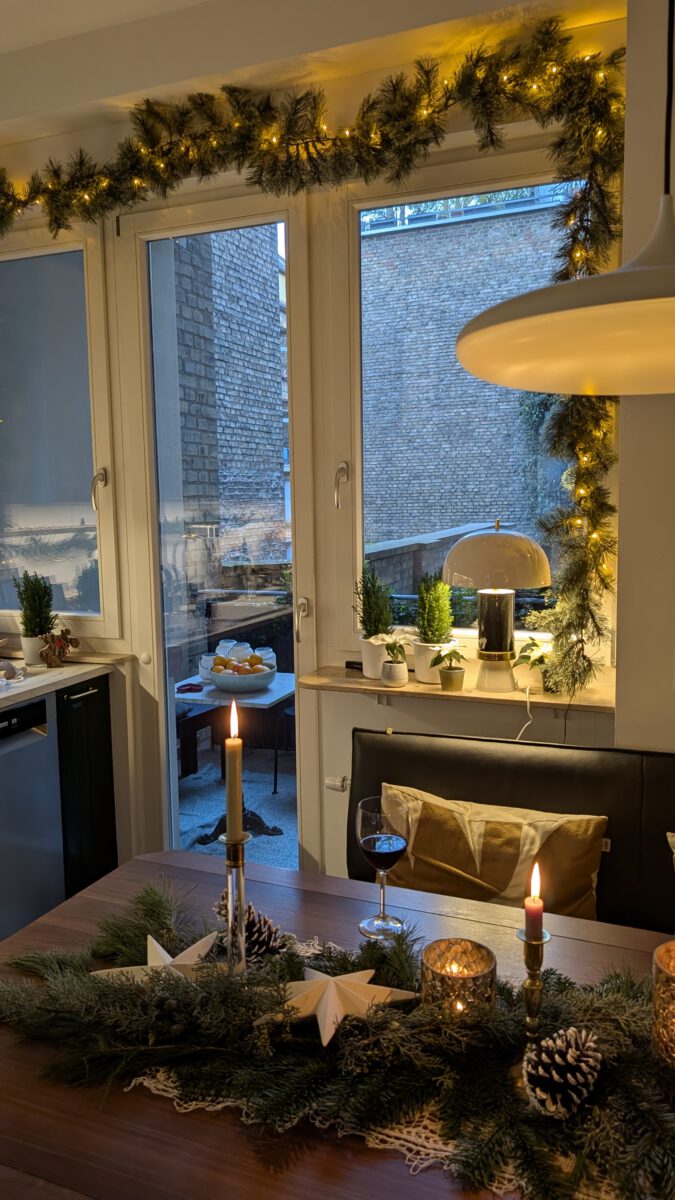 Eine beleuchtete Tannengirlande im Fenster sorgt für festliche Weihnachtsstimmung.