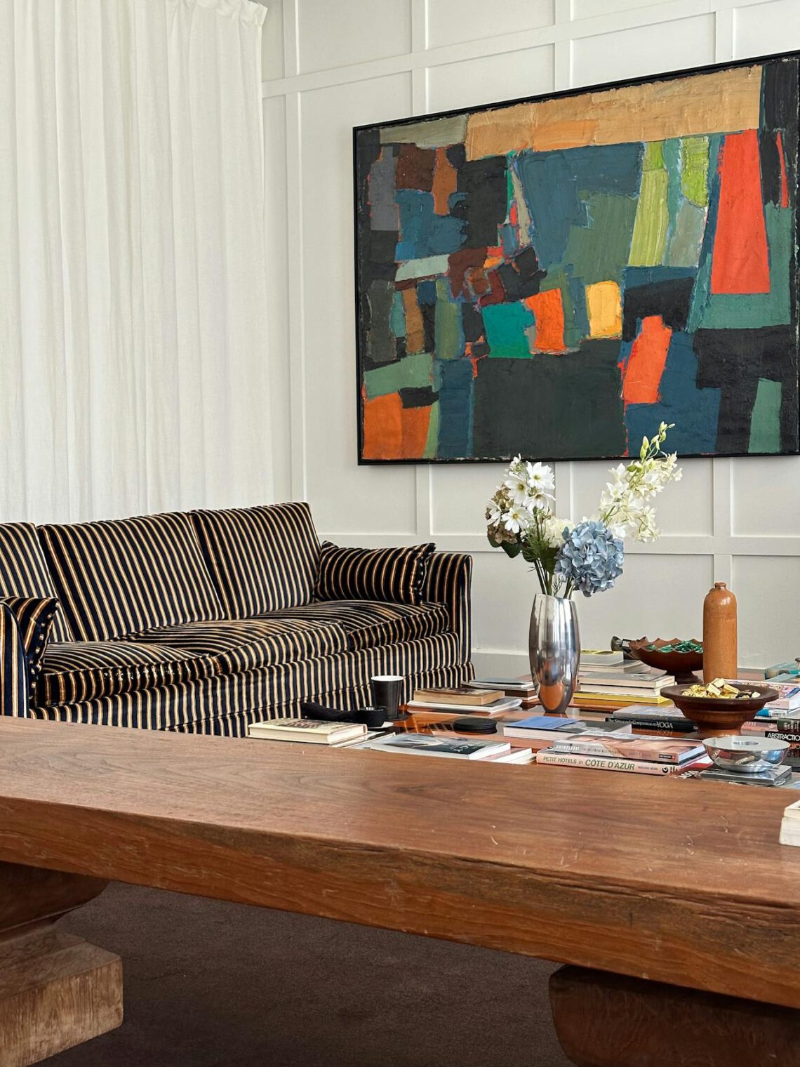 ein eklektisches Wohnzimmer mit einem Sofa, das mit einem gestreiften Stoff bezogen ist